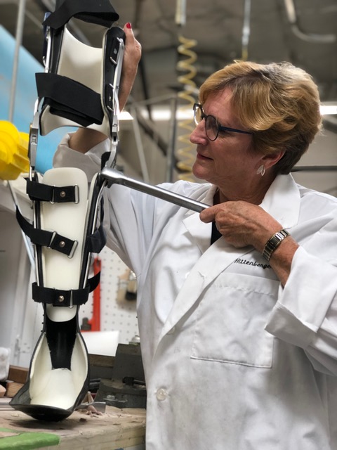 Ms. Hittenberger adjusts a knee-ankle-foot orthosis, or KAFO.