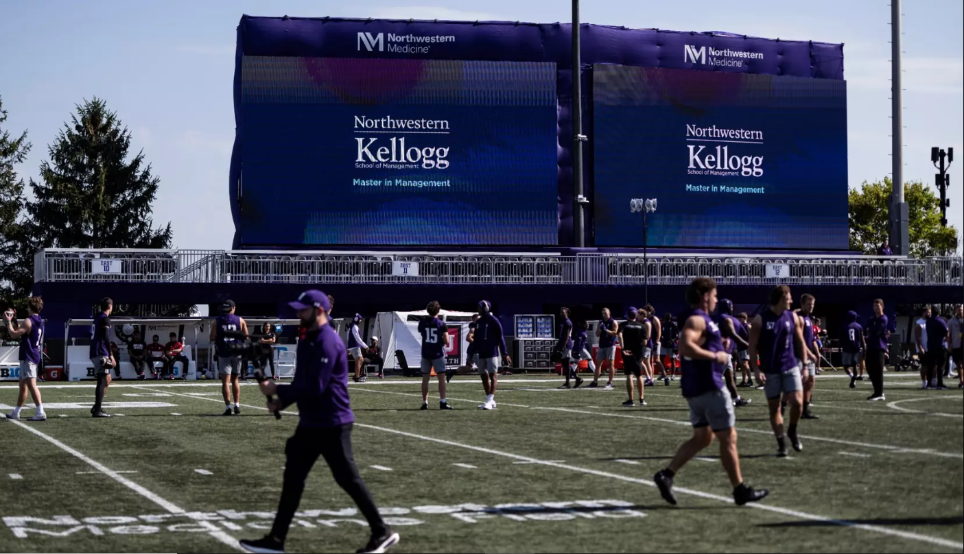 Football coaches and athletes practicing on field